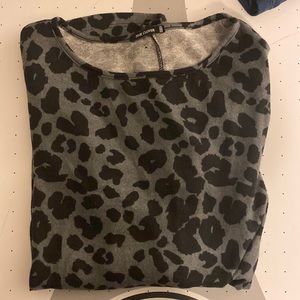 Black and grey leopard print sweater with button details on the back